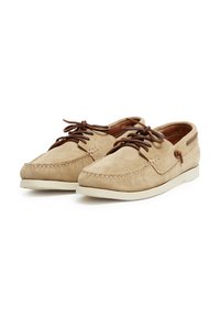 Beige Wildlederschuhe mit braunen Schnürsenkeln, einer gesteppten Nahtdetail und einer cremefarbenen Gummisohle. Abgerundete Zehen und niedriges Profil-Design.