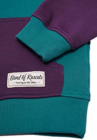 Lila och teal crewneck sweatshirt med ribbade ärmar och en etikett som står "Band of Rascals, Finest Organic Kids Clothes."