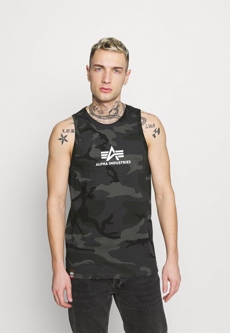 Čierny a šedý maskáčový tielko s okrúhlym výstrihom a bielym logom "Alpha Industries" na prednej strane. Tkanina má hladkú textúru.