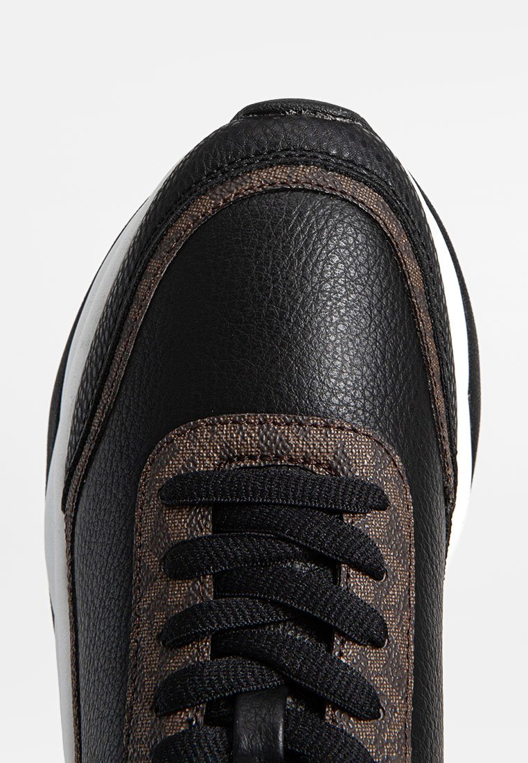 Zwarte leren sneakers met een getextureerd bruin stoffen paneel, zwarte veters en een witte rubberen zool. Voorzien van gestikte accenten bij de neus.
