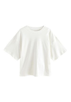 T-shirt blanc oversize à manches courtes avec encolure ronde et épaules tombantes, présenté sur un fond blanc uni.