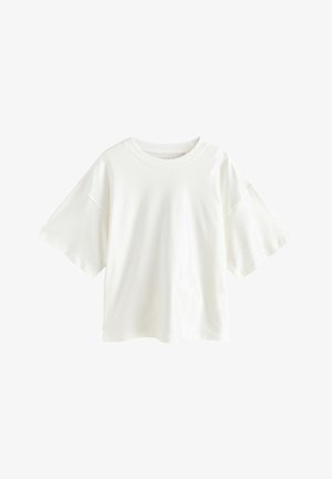 T-shirt blanc oversize à manches courtes avec encolure ronde et épaules tombantes, présenté sur un fond blanc uni.