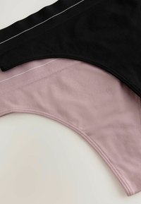 Zwei Unterwäschepaare: eines in Schwarz mit einem strukturierten Taillenbund und weißen Streifen, das andere in sanftem Rosé mit einer glatten Oberfläche.