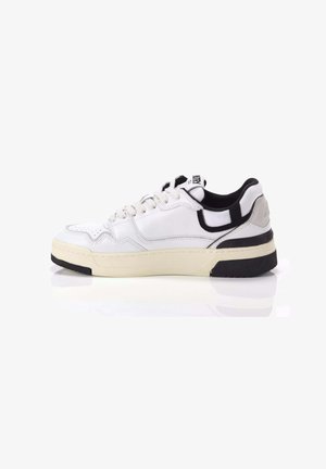 Sneaker bianca con tomaia in pelle liscia, accenti neri a contrasto, chiusura con lacci e una spessa suola in gomma crema con battistrada nero testurizzato.