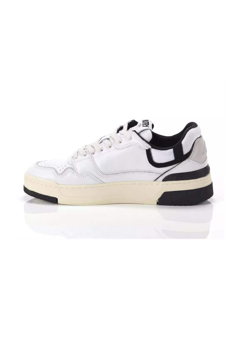Sneaker bianca con tomaia in pelle liscia, accenti neri a contrasto, chiusura con lacci e una spessa suola in gomma crema con battistrada nero testurizzato.