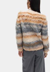 Weicher, gestreifter Pullover in Beige-, Grau- und Cremetönen mit strukturierter, lockiger Oberfläche. Lockerer Schnitt mit langen Ärmeln und abgerundetem Saum.