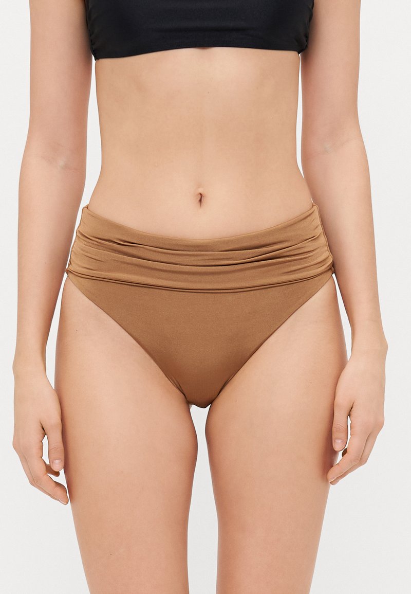 Magas derekú bikini alsó egyszínű világosbarna anyagból, ráncolt részletekkel a derékrészen, sima felülettel és illeszkedő kialakítással.
