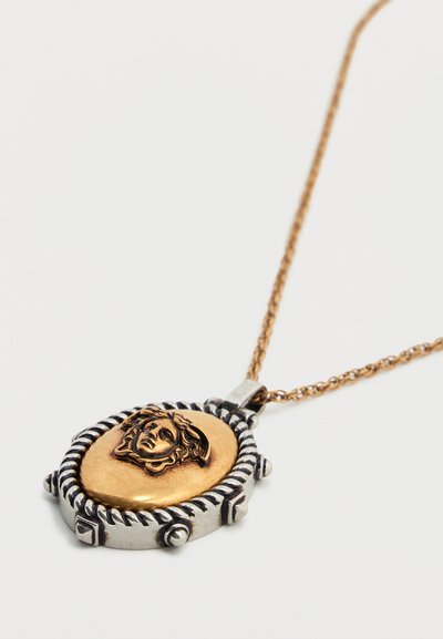 Κολιέ με χρυσό και ασημένιο μενταγιόν, με λεπτομερή ανάγλυφη σχεδίαση κεφαλιού Μέδουσας σε οβάλ μενταγιόν.
