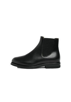 Botte Chelsea en cuir noir avec panneaux latéraux élastiques, bout arrondi, talon bas et finition lisse et polie.