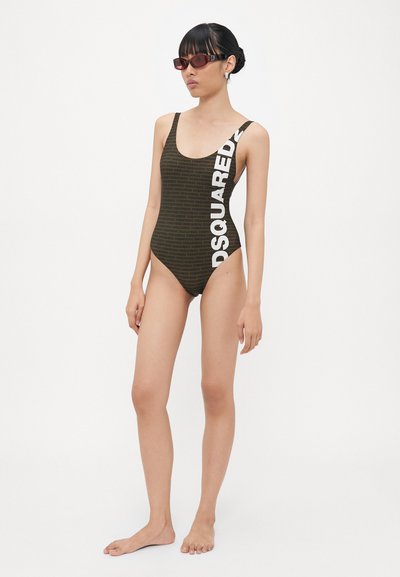 Pruun ühes tükis ujumispüksid, millel on diagonaalne valge "DSQUARED2" logo, ümmargune kaelus ja minimalistik disain, valmistatud siledast materjalist.