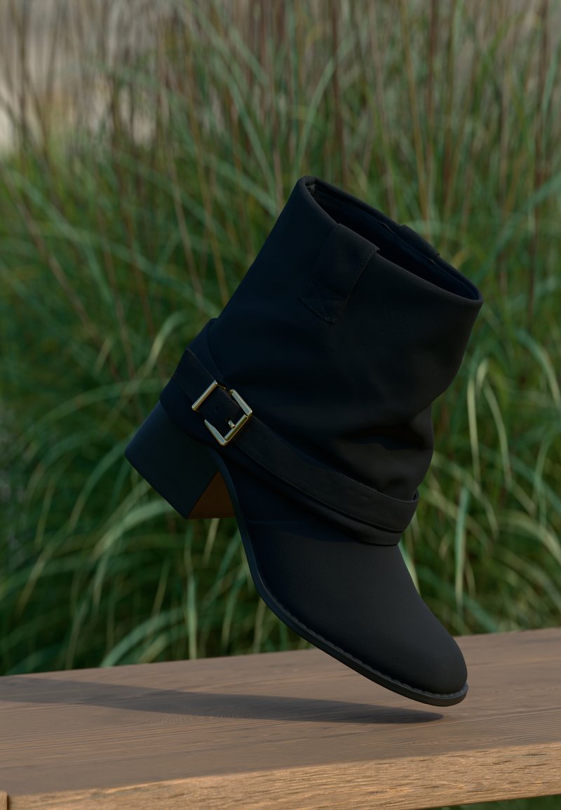 Mustad pahkluu saabast, mis on valmistatud siledast materjalist, varustatud voltitud ülaosaga, laia kuldse pandlaga rihmaga ja madala kontsaga.