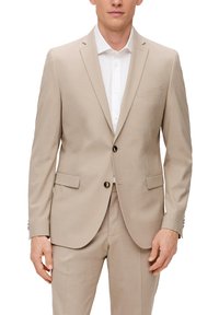Beige Anzug mit strukturierter Oberfläche, einreihiges Design, Reverskragen und zwei Vordertaschen. Weißes Hemd darunter, sichtbare Knöpfe.