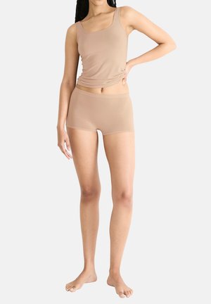 Beige naadloze tanktop en short set, gemaakt van een soepele stof. De tanktop heeft brede bandjes en een vierkante halslijn; de shorts hebben een eenvoudig, nauwsluitend ontwerp.