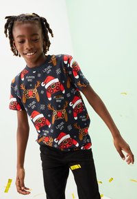 Kurzärmeliges, marineblaues Baumwoll-T-Shirt mit einem verspielten Muster aus Spielecontrollern, Rentieren, Schneeflocken und festlichen Elementen in Rot und Weiß.