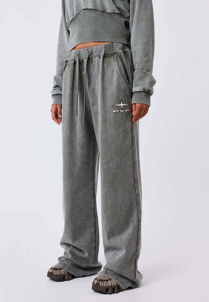 Grijze, oversized sweatpants met zijzakken, een trekkoord taille en een geborduurd logo op de dij. Gemaakt van zachte, gestructureerde stof.