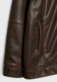 Giacca marrone in pelle sintetica dalla texture liscia, con tasche laterali, dettagli cuciti e design elegante e aderente.