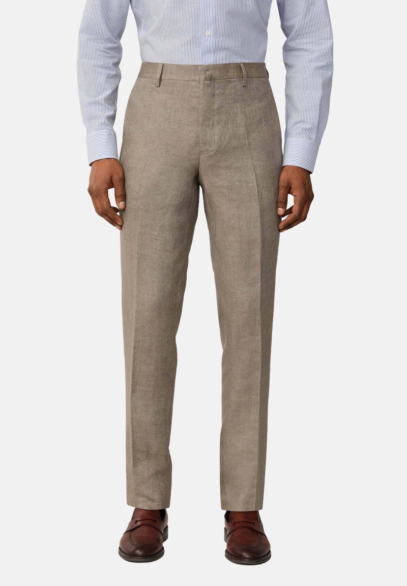 Beige linen trousers with a tailored fit, featuring a flat front and crease lines, paired with dark brown leather shoes.