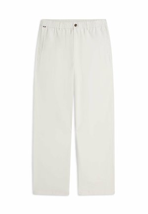 Pantalon droit couleur blanc cassé avec taille élastique, fermeture par bouton, poches latérales et un petit détail en tissu tricolore près de la poche gauche.