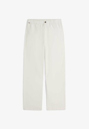 Pantalon droit couleur blanc cassé avec taille élastique, fermeture par bouton, poches latérales et un petit détail en tissu tricolore près de la poche gauche.