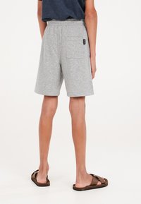 Shorts di cotone grigi con vita elastica, dotati di una tasca posteriore e di un piccolo etichetta del marchio. Tessuto liscio, design fino al ginocchio, vestibilità casual.