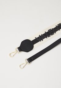 Tracolla per handbag nera e crema con un grande logo "VALENT", dettagli in pelle testurizzata e clip in metallo dorato.
