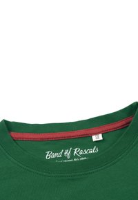 Vihreä t-paita pyöreällä kaula-aukolla. Ribattu kaulus, jossa on punainen sisäverhoilu. Kaula-aukossa on teksti-logo "Band of Rascals". Puuvillakangas.