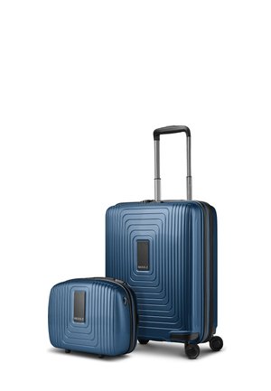 Dos maletas rígidas azules con patrones geométricos texturizados, una grande con ruedas y asa telescópica, una neceser más pequeño.