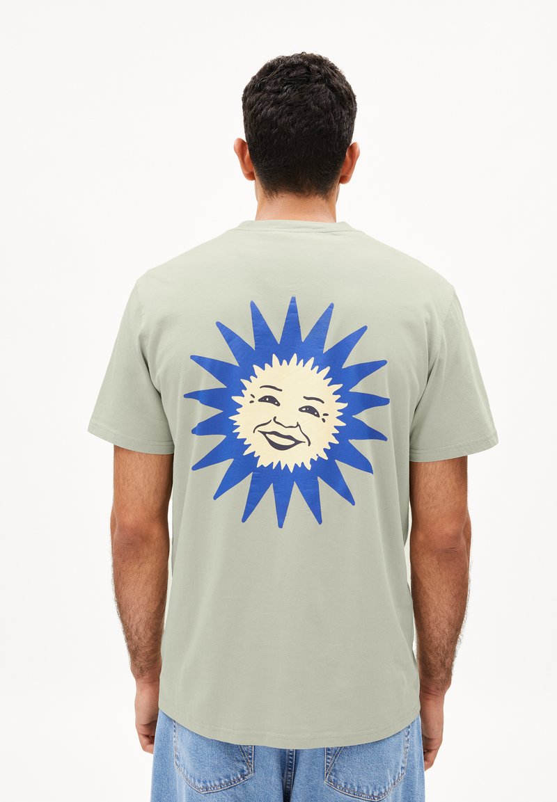 Groene katoenen t-shirt met een groot blauw zonontwerp met een lachend gezicht op de achterkant. Korte mouwen en een relaxed fit.