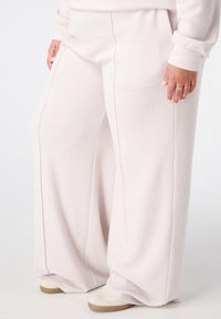 Lichtroze wijde sweatpants van ribbeltextuur, met een relaxte pasvorm, elastische tailleband en zijnaaddetails.