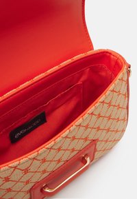 Prostokątna torebka z beżowym, teksturowanym zewnętrzem ozdobionym pomarańczowym geometrycznym wzorem. Jasno pomarańczowa podszewka i elementy metalowe.