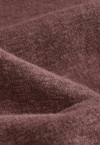 Tekstūru audums dziļi mauve krāsā, demonstrējot mīkstu, austu rakstu ar redzamām šķiedrām un maigiem krokām.