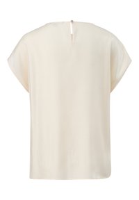 Kremowa bluzka z krótkimi rękawami, gładka w dotyku, z zapięciem w kształcie dziurki na plecach z okrągłym guzikem oraz luźnym, prostym krojem.