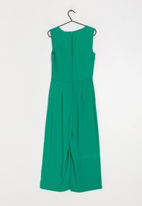 Mono verde con diseño sin mangas, cierre de cremallera en la parte trasera, frente plisado y piernas anchas. Confeccionado con un material suave.