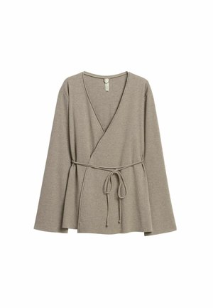 Beige geribbelde wikkeltrui met lange mouwen, V-hals en een ceintuur in de taille. Zachte textuur, losse pasvorm en uitlopende zoom.