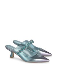 Mules à bout pointu en cuir bleu clair irisé avec un talon bloc de hauteur moyenne, dotées d'une sangle ornée de bijoux sur le cou-de-pied.