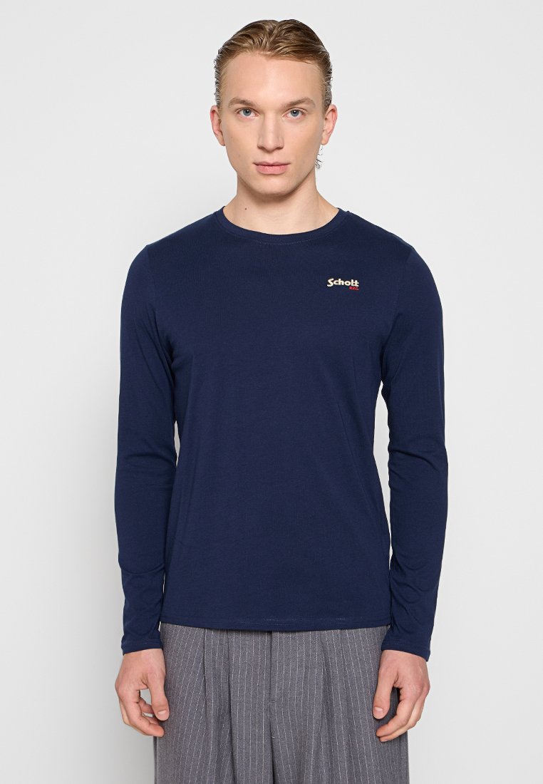 Marineblaues Langarm-T-Shirt aus weicher Baumwolle, mit Rundhalsausschnitt und dezentem roten Logo auf der linken Brust. Schlichte Textur.