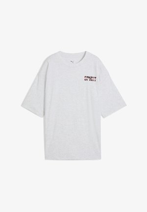 Gaiši pelēka, pārāk liela T-krekla ar vārdu "SPIRIT" sarkanā un melnā krāsā kreisajā pusē. Īsas piedurknes un apaļa kakla izgriezne.