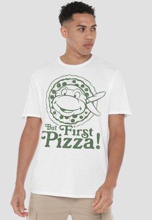 White cotton t-shirt featuring a green graphic of a pizza with a smiling character and text that reads "But First Pizza!" beneath.