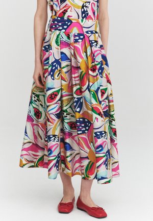 Floral midi dress with bold pink, blue, green, and yellow prints, paired with red ballet flats on a standing person.