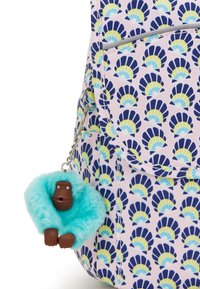 Muster-Rucksack mit einem pinken Hintergrund und navyblauen sowie gelben Muschelmotiven. Ein flauschiger türkiser Schlüsselanhänger mit einer braunen Affenfigur schmückt ihn.