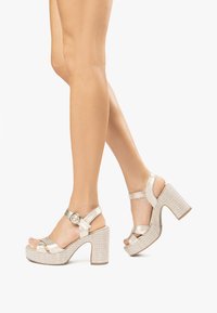 Sandales à plateforme en satin argenté avec un talon bloc tissé texturé, sangle réglable et détail de boucle ronde. Design à bout ouvert.