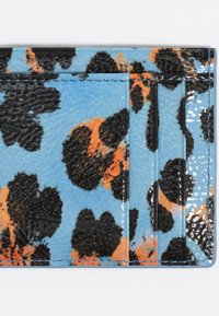 Portacarte testurizzato con sfondo blu e macchie di leopardo nere e arancioni, rifinito in materiale lucido con diverse tasche per schede.