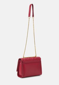 Borsa a tracolla rossa in pelle con catena dorata, forma rettangolare e motivo con logo in rilievo sulla pattina. Tocco liscio con un design strutturato.
