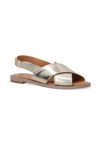 Gouden metalen slingback sandaal met kruislings banden en open teen. Beschikt over een platte zool en een lichtgeprofileerde inlegzool voor comfort.