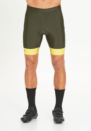 Herre cykeltights i olivengrøn med gule accentbånd ved kanten. Har åndbart stof og en polstret sæde for komfort.