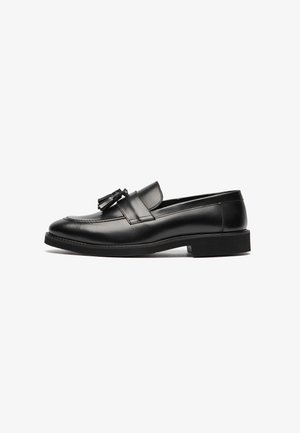 Zwarte leren loafers met een gladde oppervlakte, een ronde neus en een decoratieve kwast op de band. Platte zool en subtiele stikseldetails.