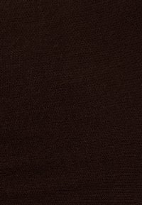 Tamsiai ruda megzta medžiaga su tankiu, vienodu audimo raštu ir minkštu paviršiumi.