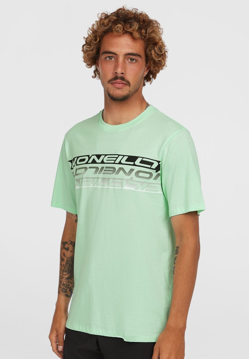 Camiseta de manga corta en verde menta, hecha de tela suave, con un atrevido logo en negro y plata en el pecho y un ajuste relajado.