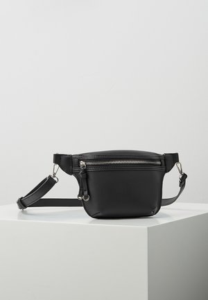 Zwarte leren heuptas met zilveren ritssluiting en verstelbare band, geplaatst op een wit voetstuk tegen een effen achtergrond.