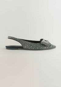 Juodas plokščias batas su užsegimu ant kulno, puošiamas mažomis baltomis sagtelėmis ir dekoratyvia mazgo detaile prie pirštų. Lygus juodas padas.